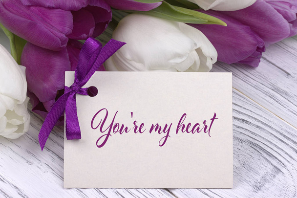 Carte de voeux Saint-Valentin, ruban violet blanc tulipes, fond en bois blanc
. - Photo, image
