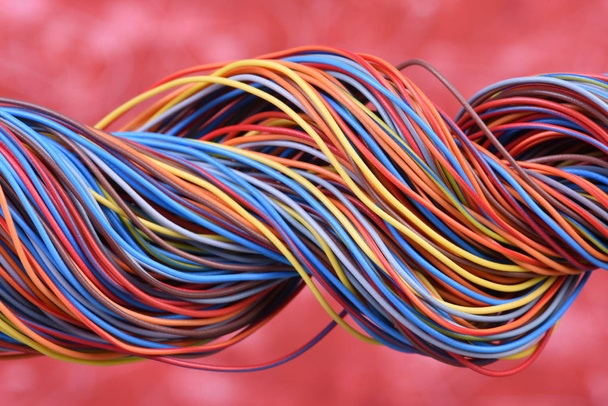 Veelkleurige Elektrische kabelproducten op rode achtergrond - Foto, afbeelding