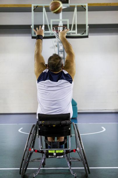 Disabili uomini sportivi in azione mentre giocano a basket al coperto - Foto, immagini