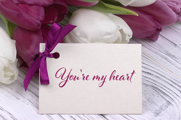Вітальна листівка на день Святого Валентина, тюльпани біло-фіолетова стрічка, білий дерев'яний фон
. - Фото, зображення