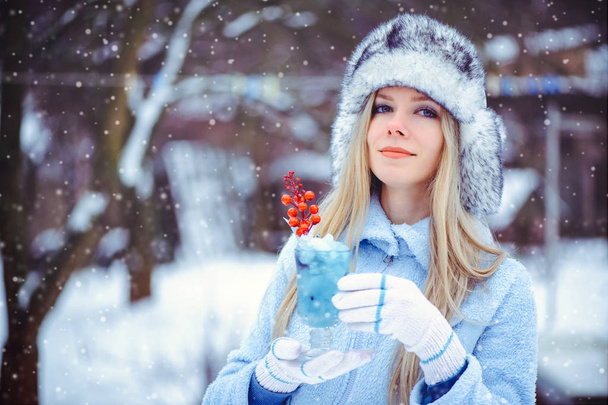 πορτρέτο του ένα απαλό λαμπερό γυναίκα σε ένα χειμερινό καπέλο με ένα χειμώνα Δρίνο - Φωτογραφία, εικόνα