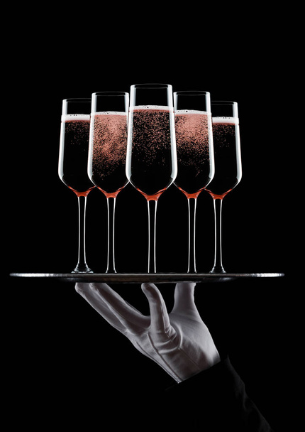 Hand with glove holds tray with champagne glasses - Photo, image