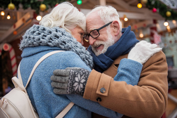 Affectionate elderly man and woman hugging outside - Foto, Imagem
