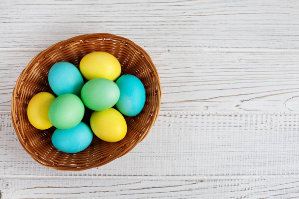 Colored eggs in basket. Top view. Concept Happy Easter. - Foto, Bild