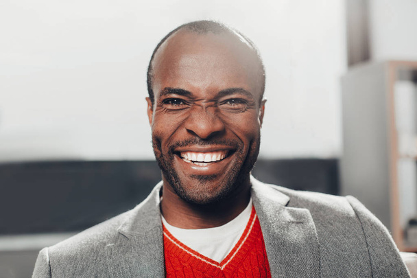 lachender afrikanischer Geschäftsmann, der vor Freude starrt - Foto, Bild