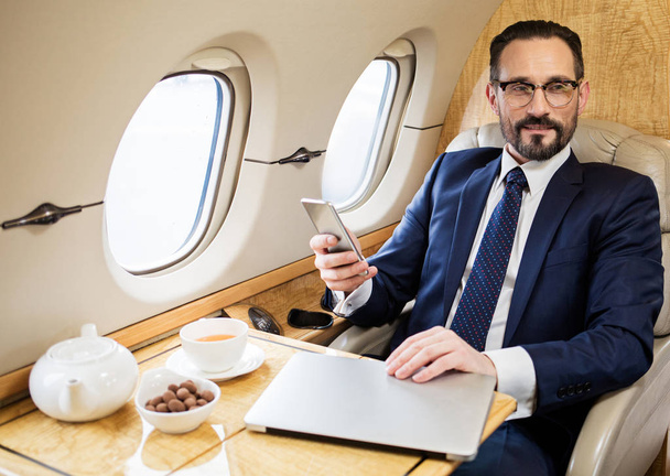 Pleased middle aged man enjoying first class flight - Photo, Image