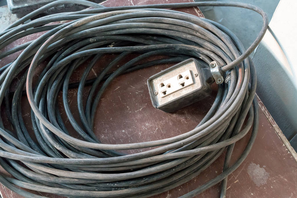 A white extension power cord with a very long cable for construc - Photo, Image