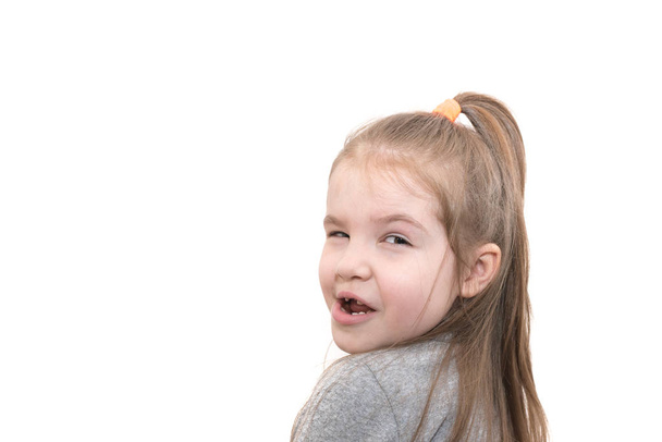 Beautiful little girl, surprised and indignant, looking over her shoulder isolated on white background - Photo, Image