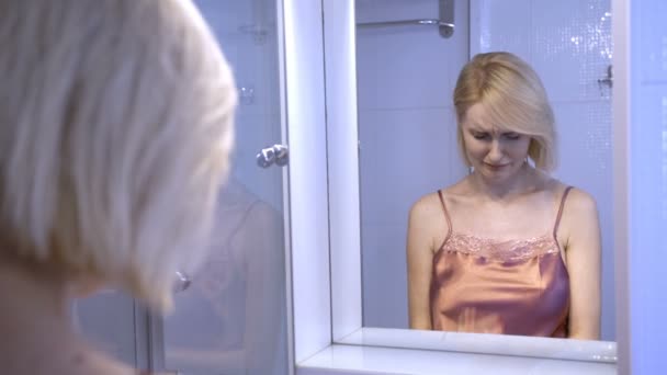 Odbicie smutna kobieta płacze w pobliżu lustra - Materiał filmowy, wideo
