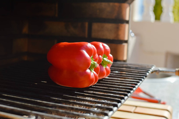 Close-up op paprika's klaar voor het roosten op de grill, zonnige dag buiten achtergrond - Foto, afbeelding