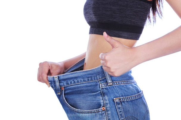 close up slim woman in old jeans showing thumbs up isolated on w - Photo, Image