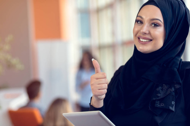 Mooie vrouw het dragen van hijab voor laptop zoeken en doen kantoor werken, business, financiën en werkstation concept. - Foto, afbeelding