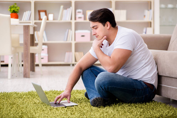 Człowiek pracujący na laptopie w domu na podłodze dywanu - Zdjęcie, obraz