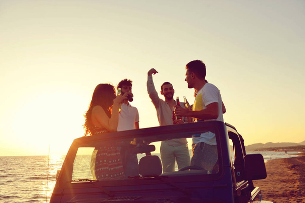 Group of happy friends making party in car - Young people having fun drinking champagne - 写真・画像