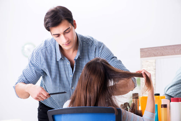 Man male hairdresser doing haircut for woman - Fotó, kép
