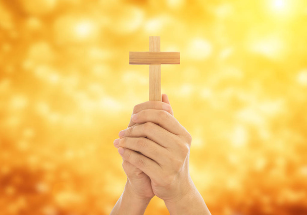 menschliche Hände, die ein heiliges Kreuz halten und um Gottes Segen beten. amour worship God concept. - Foto, Bild