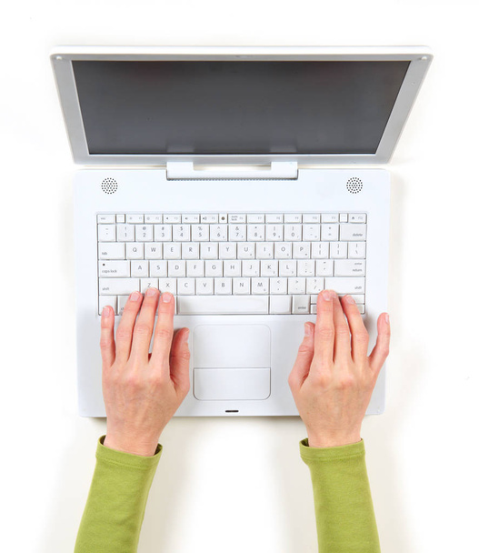 Ręce w zielona kurtka i biały laptopa - Zdjęcie, obraz