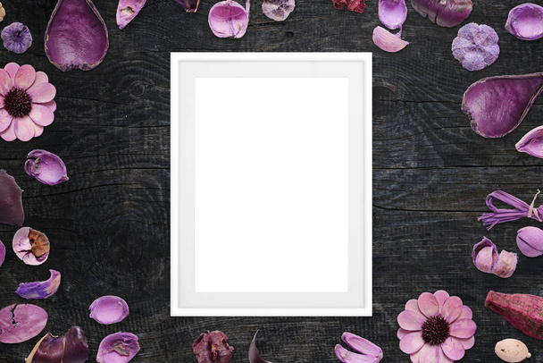 Picture frame on black wooden desk surrounded with purple floral decorations. - Zdjęcie, obraz