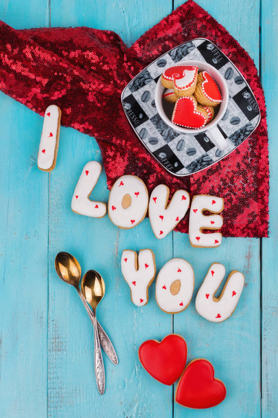 Biscotti fatti in casa sotto forma di cuore o ti amo parole a San Valentino su una lavagna blu vista dall'alto
 - Foto, immagini