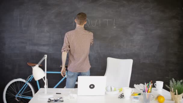 4K businessman in creative office writing 'I quit' on blackboard - Кадри, відео