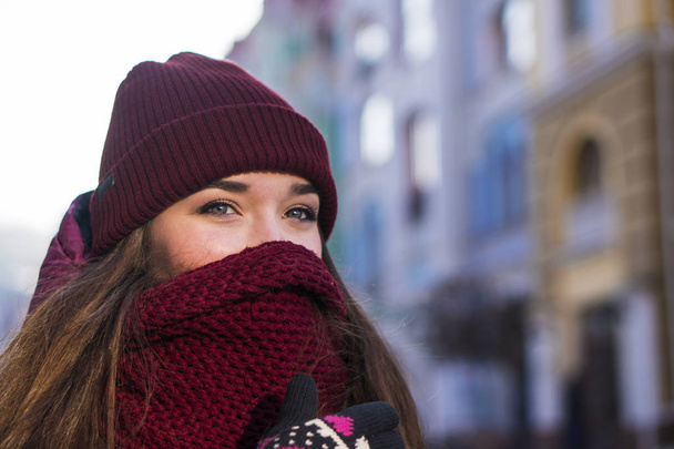 Pretty Brunette Girl Wearing Purple Winter Coat, Hat and Scarf, Walking by European Street at Winter, Wrapped up in a Scarf. - Foto, Imagem