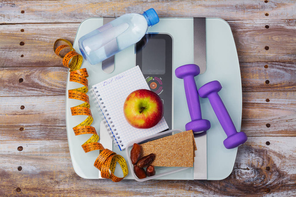 Balança de peso, lanches saudáveis, halteres e fita métrica. Alimentação saudável, dieta ou conceito de perda de peso
 - Foto, Imagem