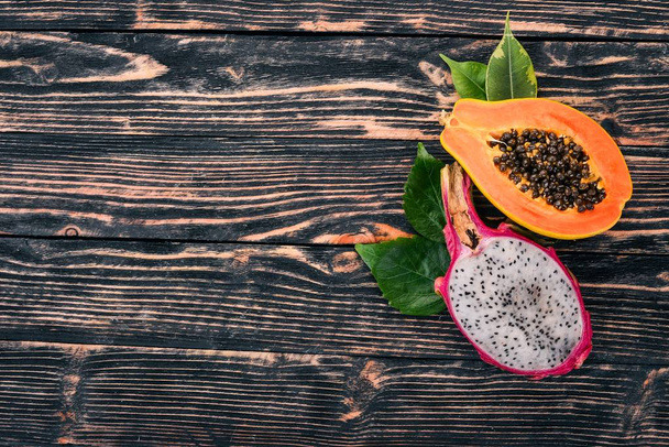 Papaya and Dragon Fruit. Fresh Tropical Fruits. On a wooden background. Top view. Copy space. - Фото, изображение