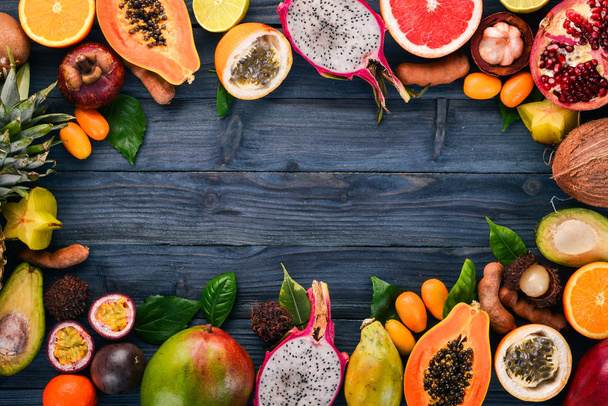 Tropical fruits, papaya, Dragon Fruit, rambutan, tamarind, cactus fruit, avocado, granadilla, carambola, kumquat, mango, mangosteen, passionfruit, coconut. On a wooden background. - Fotografie, Obrázek