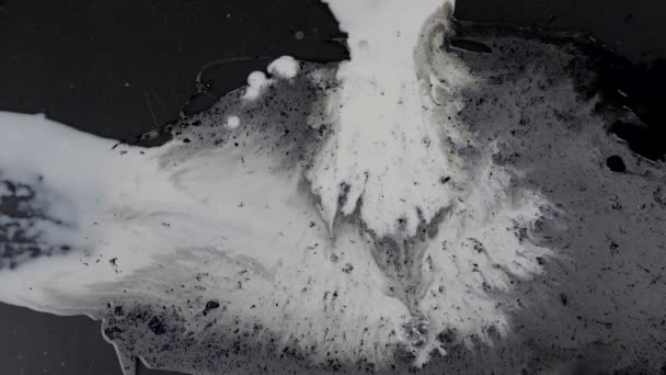 Salpicadura de diferentes líquidos blancos sobre fondo oscuro
 - Metraje, vídeo