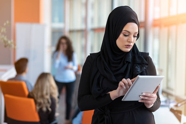 Bella donna che indossa hijab di fronte alla ricerca di laptop e fare lavoro d'ufficio, business, finanza e concetto di workstation
. - Foto, immagini