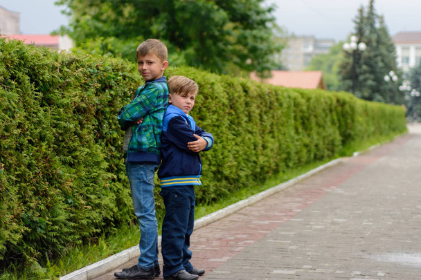 Dva mladší bratři stojící v ulicích svého města zády k sobě - Fotografie, Obrázek