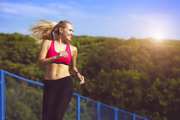 Smiling sport woman running in park - Foto, Bild