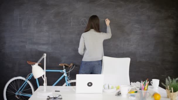4K businesswoman in creative office writing 'I quit' on blackboard - Záběry, video