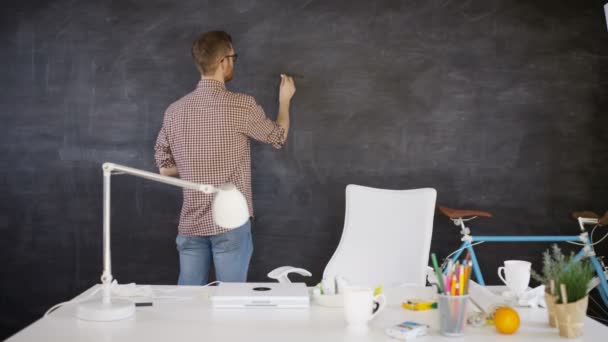 4K Man drawing light bulb on blackboard, education or creative office concept - Кадры, видео