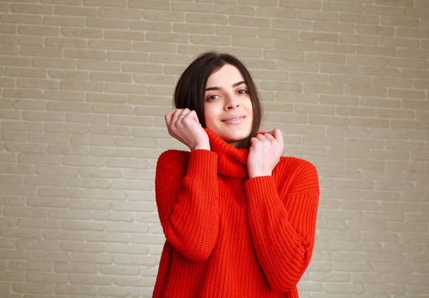 Örömteli fiatal nő piros pulóvert otthon studio - Fotó, kép