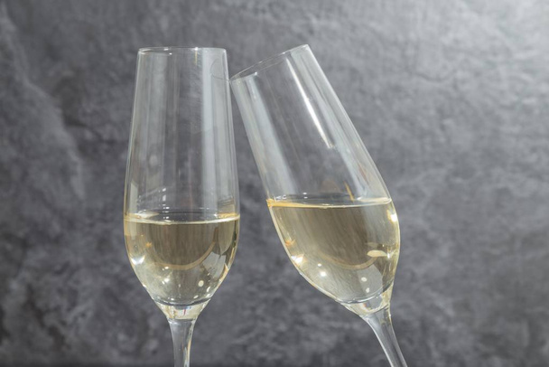 Two glasses filled with champagne in front of grey background - Photo, Image