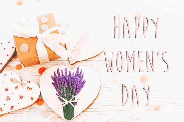 happy women's day text sign flat lay. 8 march. pink hearts  flowers and present on white rustic wooden background. space for text. greeting card concept. womens bright image - Foto, afbeelding
