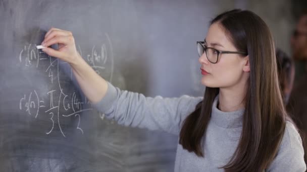 4K Young intelligent woman writing mathematical equation on blackboard - Imágenes, Vídeo