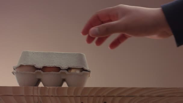 рука чоловіка відкриті яйця упаковка з 5 коричневим і одним золотим яйцем
 - Кадри, відео