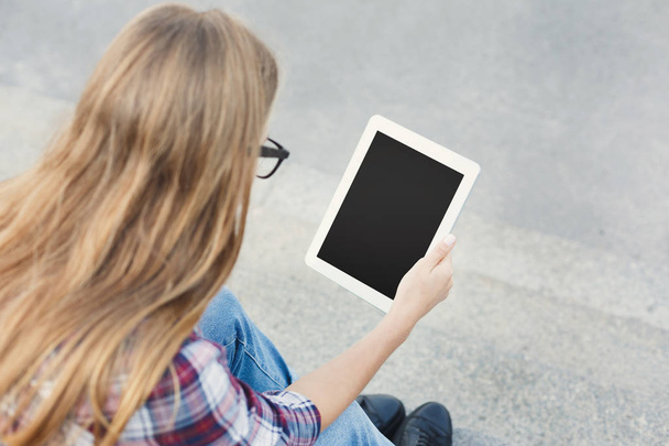 Heureuse jeune femme utilisant une tablette numérique à l'extérieur
 - Photo, image