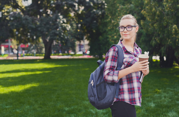 Studentin steht mit Kaffeetasse im Freien - Foto, Bild