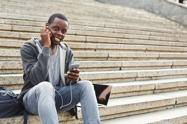 Merdivenlerde oturan ve müzik açık havada için dinleme Afrikalı-Amerikalı öğrenci - Fotoğraf, Görsel