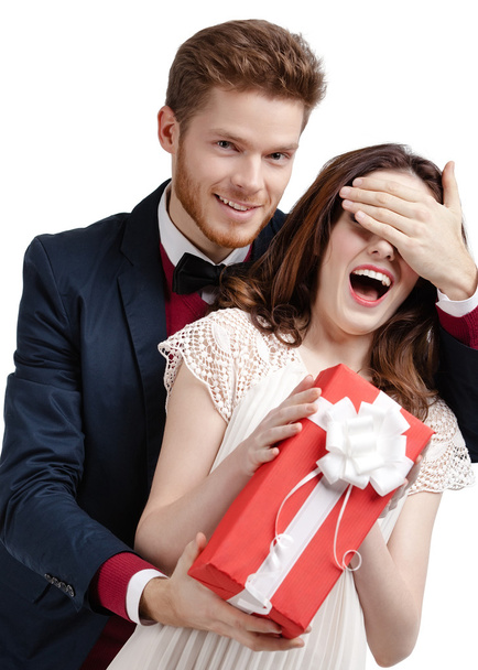 Man closes eyes of his girlfriend presenting a gift - Foto, Imagen