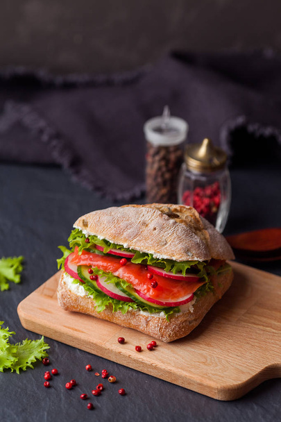 Ciabatta sandwich with salmon, vegetables and fresh salad on woo - Fotografie, Obrázek