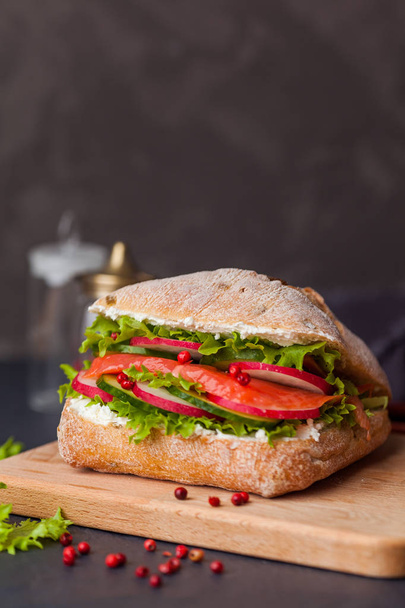 Ciabatta sandwich with salmon, vegetables and fresh salad on woo - Φωτογραφία, εικόνα