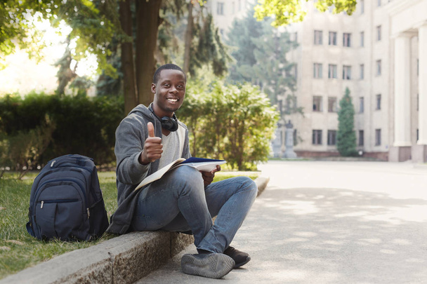 Afro-Amerikaanse student zitten met laptop in universiteitscampus - Foto, afbeelding
