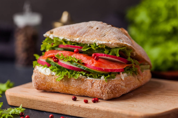 Ciabatta sandwich with salmon, vegetables and fresh salad on woo - Φωτογραφία, εικόνα