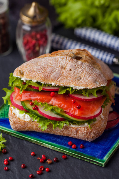 Ciabatta sandwich with salmon, vegetables and fresh salad on woo - Zdjęcie, obraz