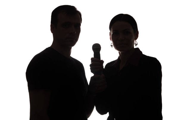 Молодий чоловік і жінка співають у мікрофон
 - Фото, зображення