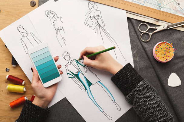 Top view on woman designer drawing clothes sketches - 写真・画像
